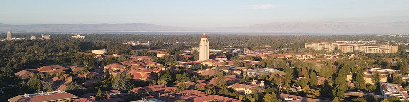 Aerial view of Stanford University with Hoover Tower at center. Mark Leschinsky, CC BY 4.0, via Wikimedia Commons.