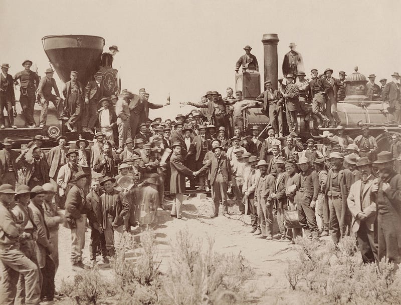 The "Champagne Photo" — May 10, 1869 at Promontory Summit, Utah. Central Pacific's Jupiter (left) meets Union Pacific's No. 119. Stanford, as CP president, drove the ceremonial Golden Spike. Andrew J. Russell, Public domain, via Wikimedia Commons.