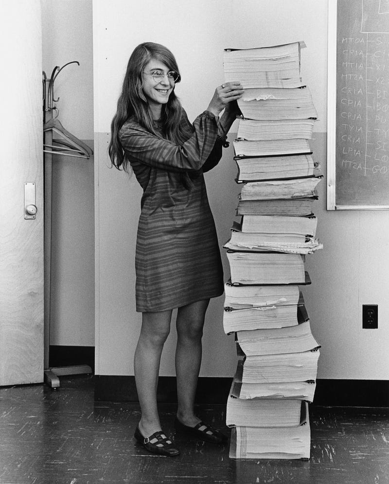Margaret Hamilton standing beside the stacked Apollo navigation software printouts, MIT, 1969